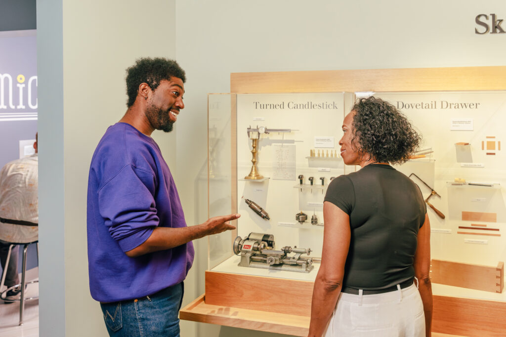 a couple talks while viewing tools used to create miniatures