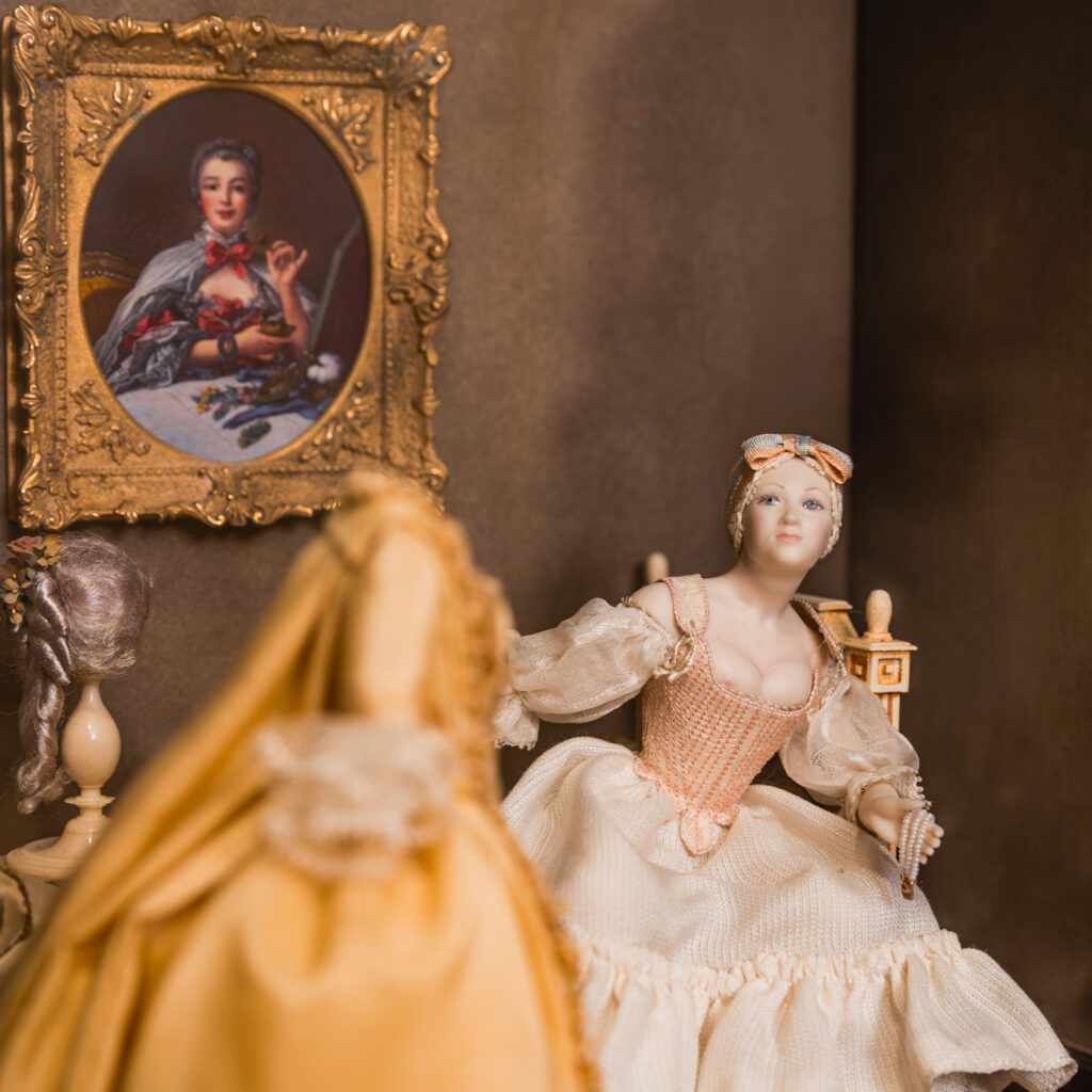 a close up of some porcelain dolls and a painting
