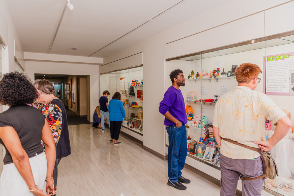a wide shot of people enjoying the timeline of toys exhibition hallway