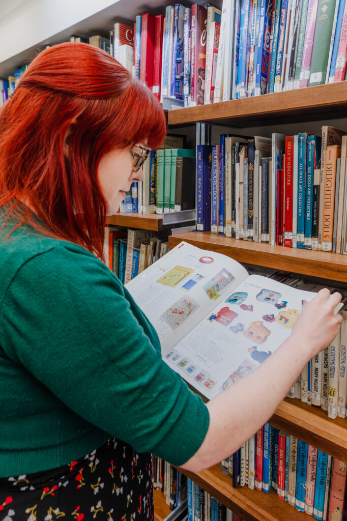 a woman is reading a book about toy history
