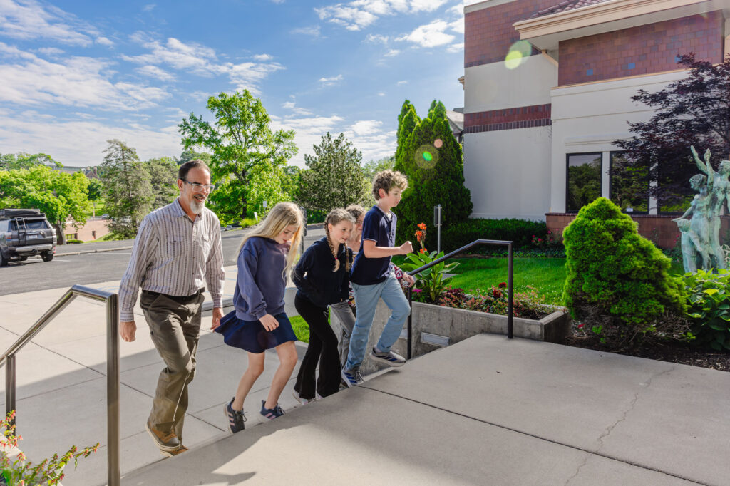 a family walks up the steps to the front of the Museum