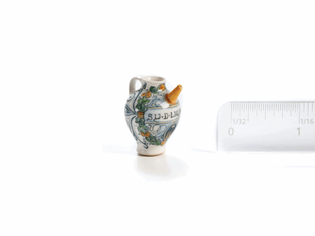 a miniature ceramic pot with a handle and a spout and floral design