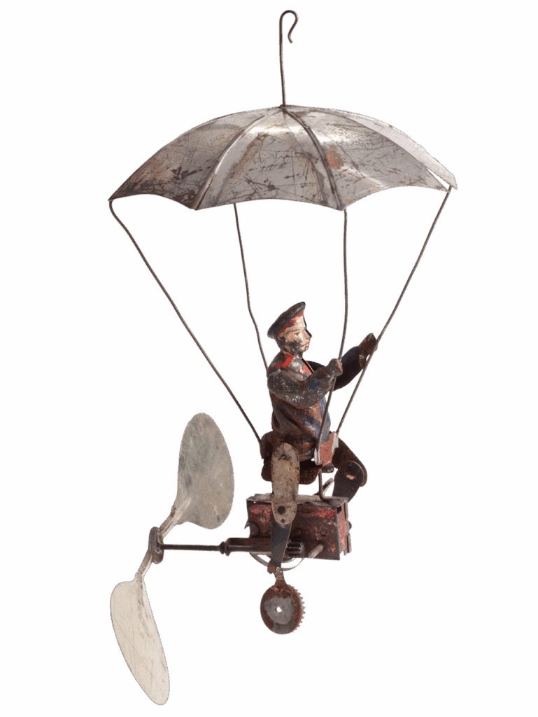 a vintage metal toy of a man on a flying machine