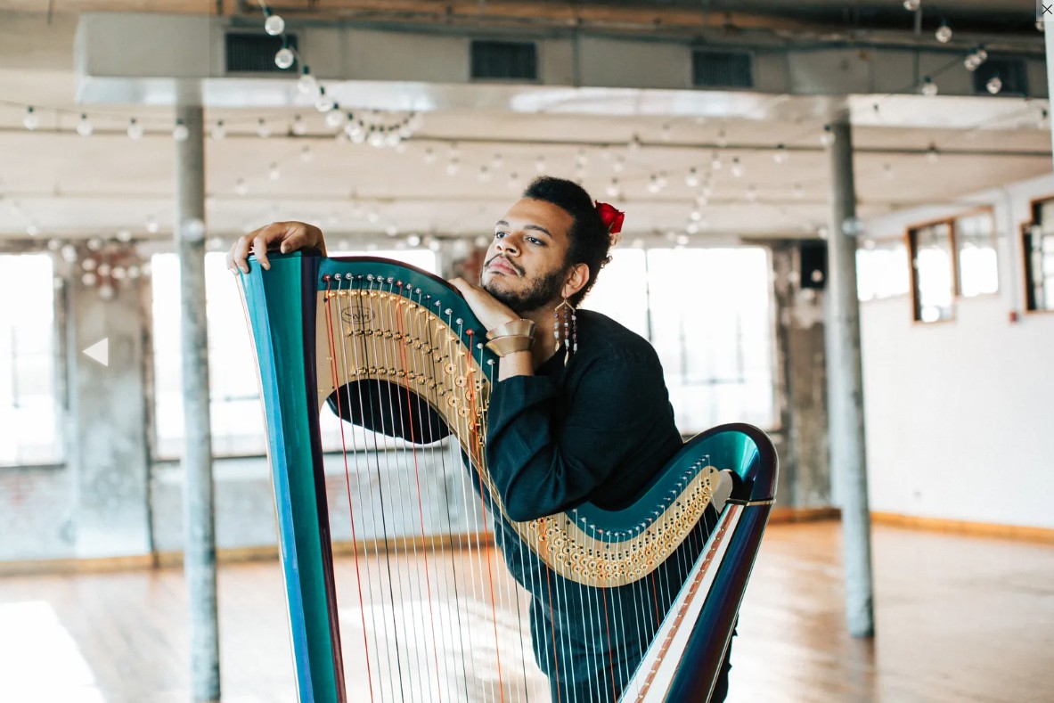 Calvin Arsenia leaning on a harp.