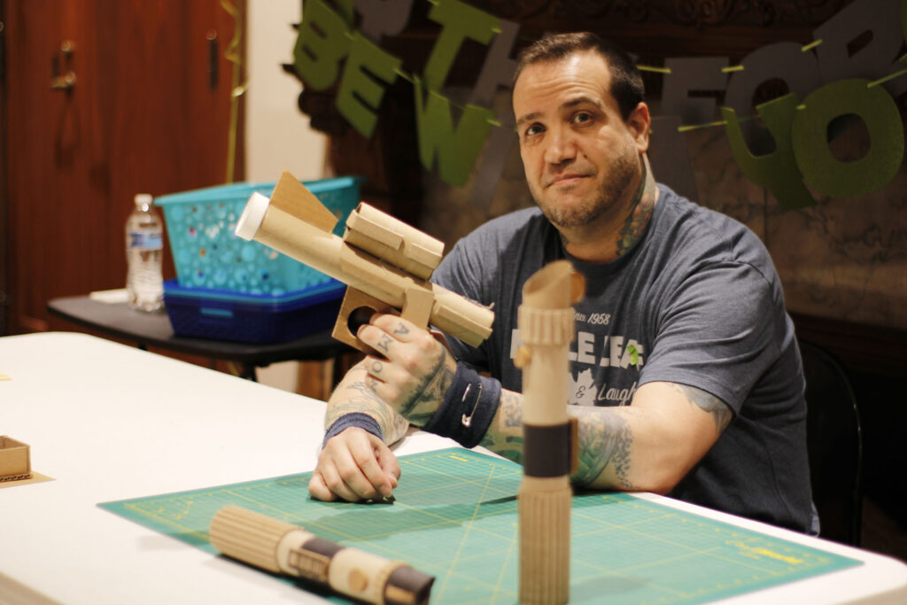 Volunteer Just Colcord showing off a cardboard raygun.