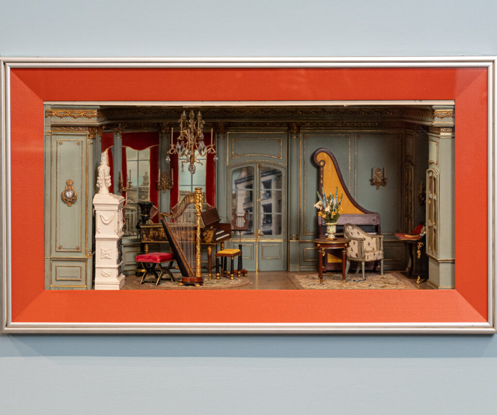 Fine-scale miniatures on a blue wall.