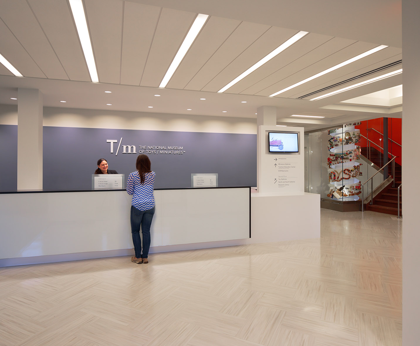 Visitor checking in at the front desk in the Museum lobby.