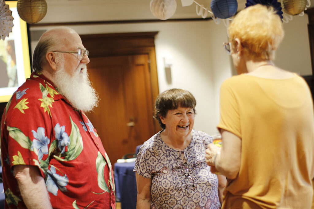 Three volunteers laughing and talking in the Tureman Mansion.
