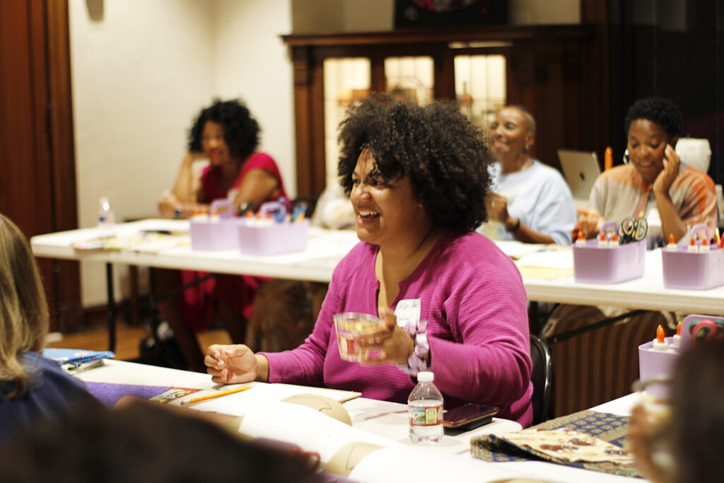 Woman drinking wine creating textile artworks.