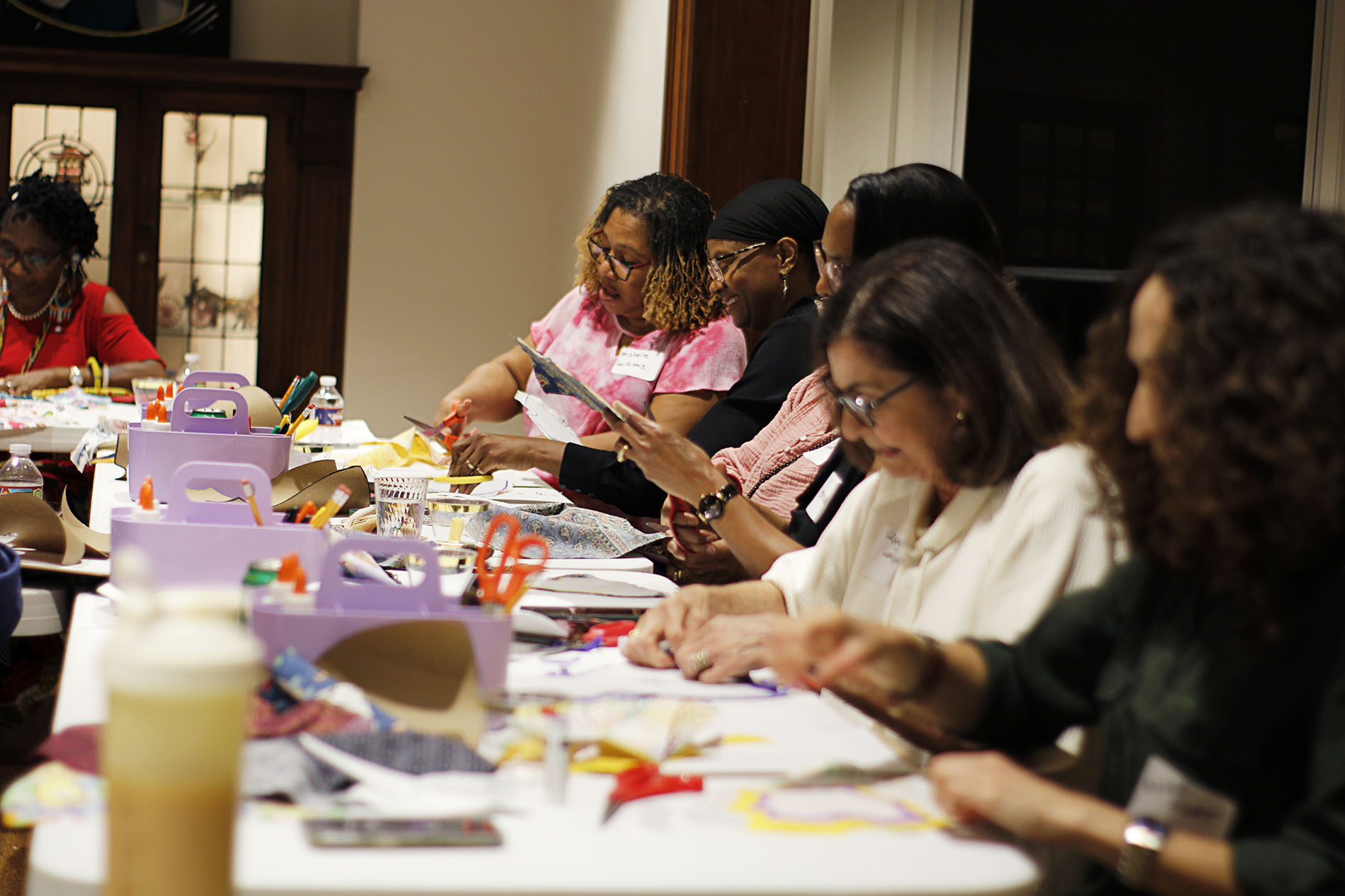 Attendees cutting out fabric at a Make and Sip event.