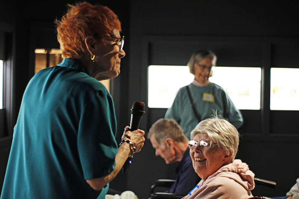 Older woman smiling during a lecture in the miniature galleries.