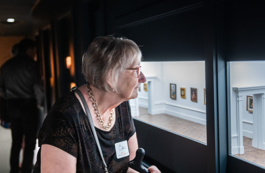 Older woman looking at the Miniature Art Museum exhibition.
