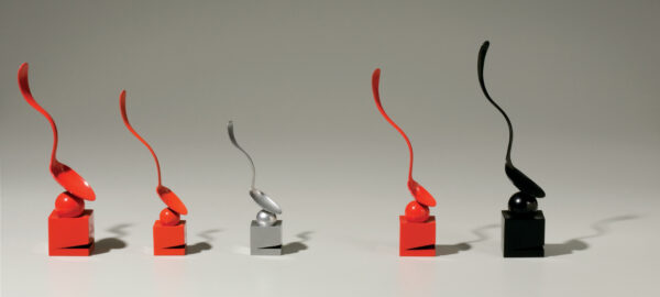 Red, silver, and black spoons lined up in a row.