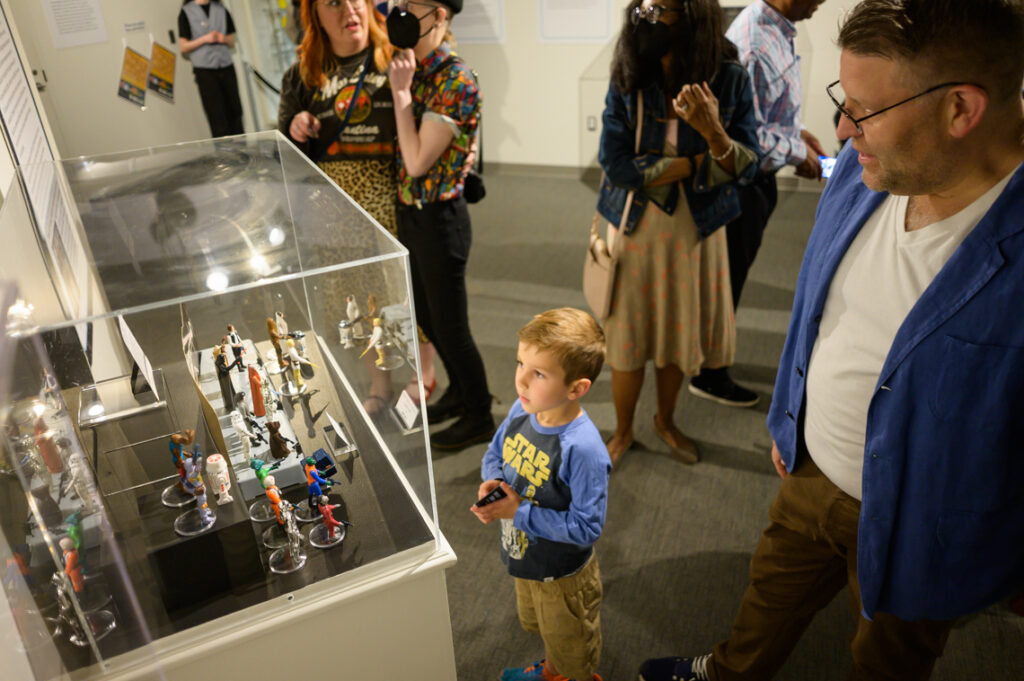 Child in Star Wars t-shirt looking at Star Wars toys.