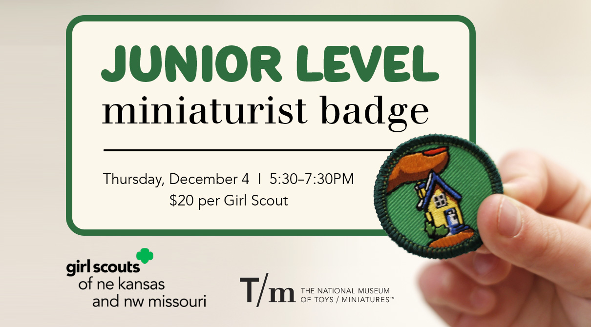 A Girl Scout's hand holding a badge with a miniature house on it.