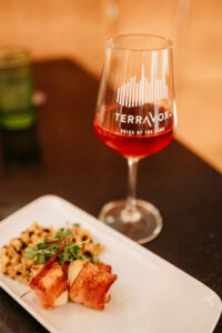 Glass of wine with TerraVox printed on it.