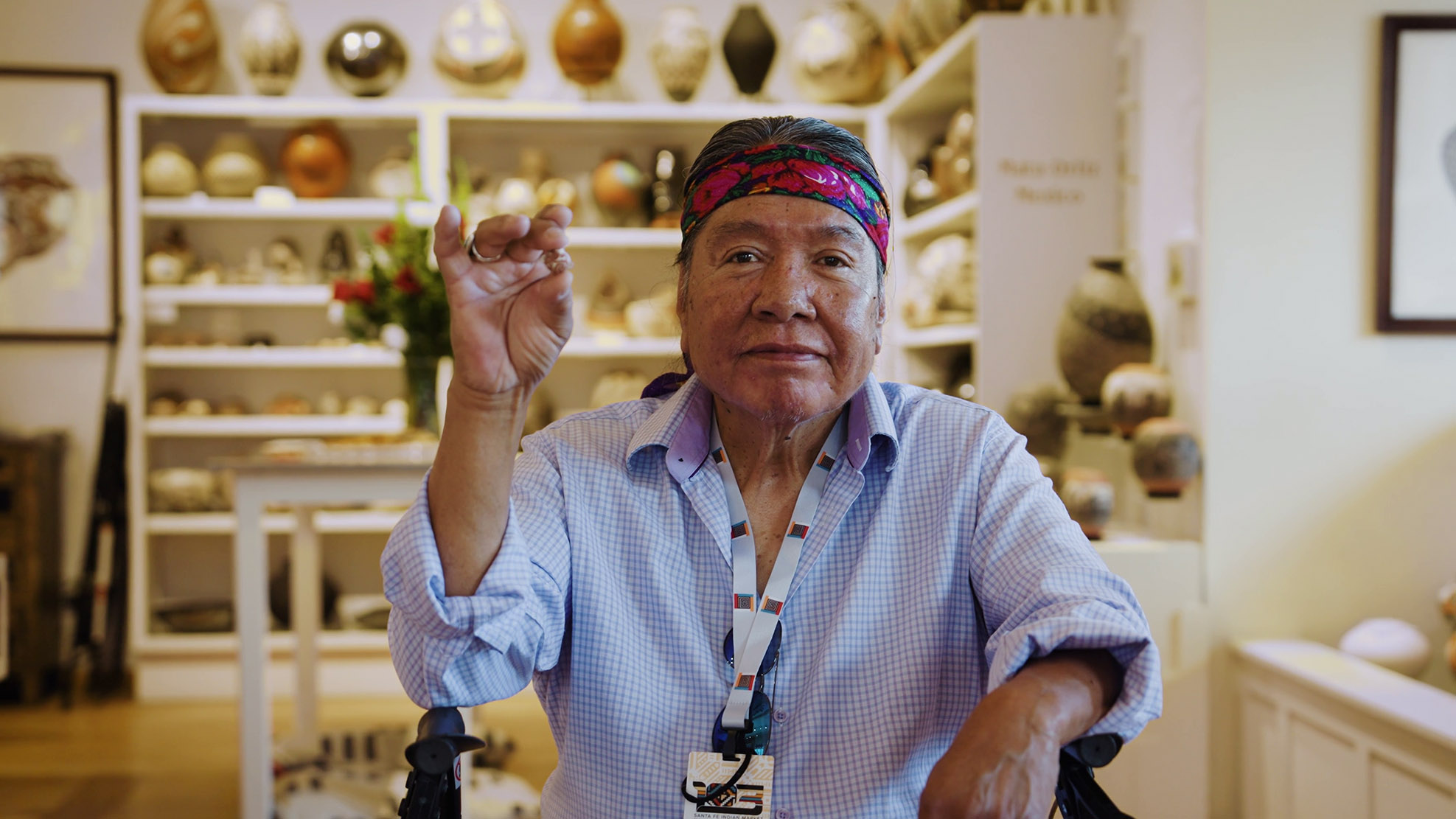 Thomas Natseway holding a miniature pot.