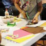A child cutting up paper during a craft.
